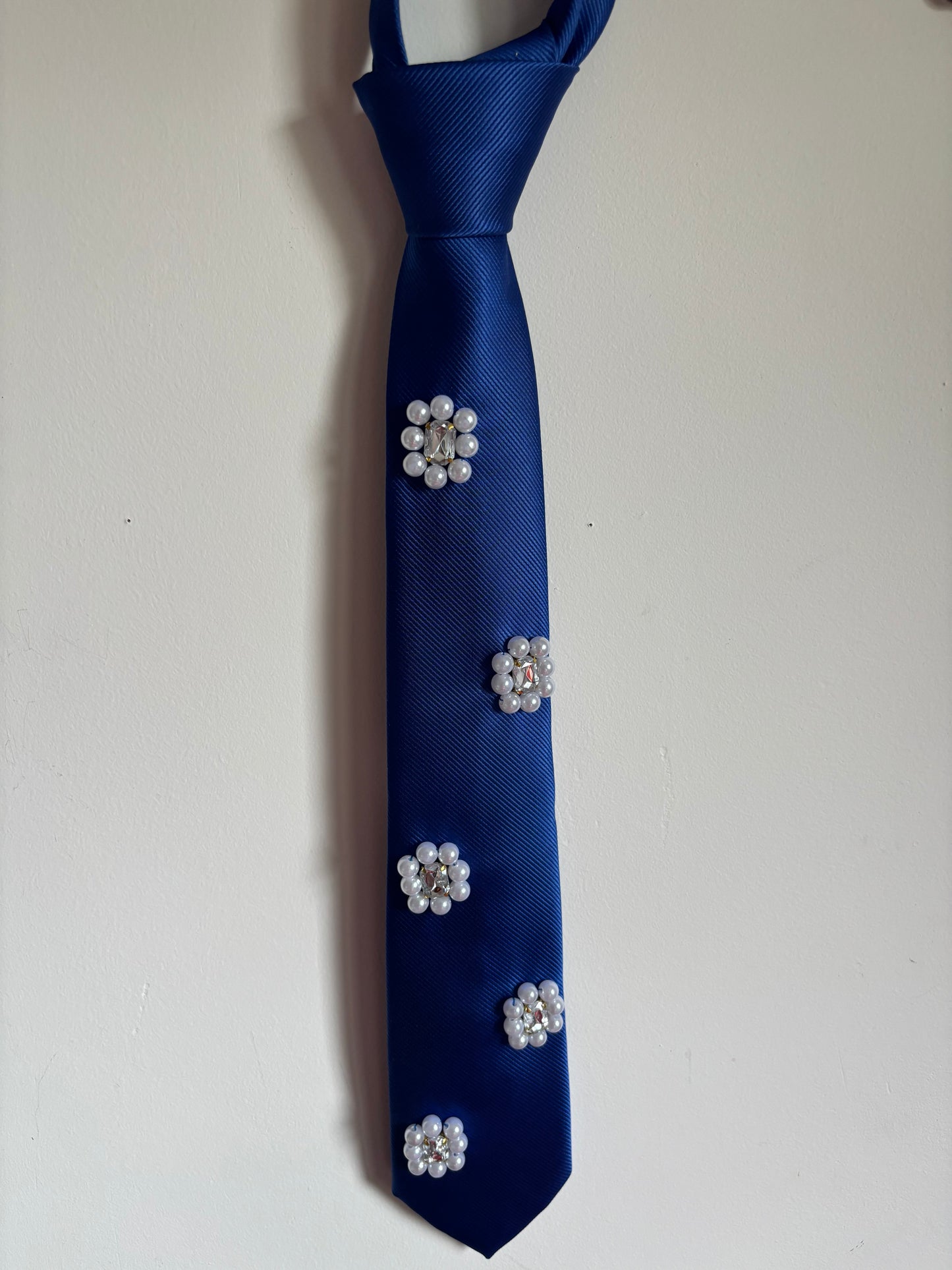 Cravate bleu foncé ornée de fleurs perlées
